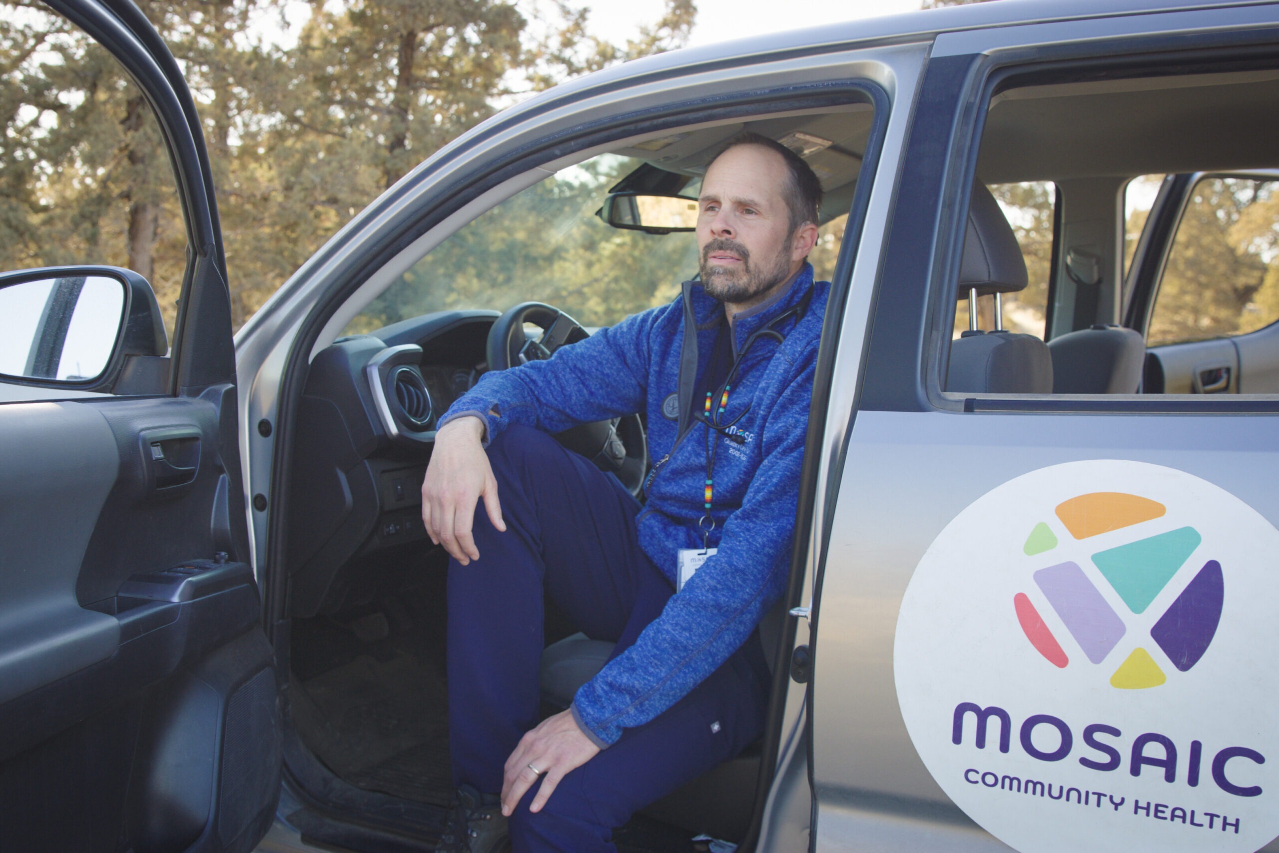 A provider with Mosaic's Street Medicine Team sits in the driver's seat of a truck with the door open.