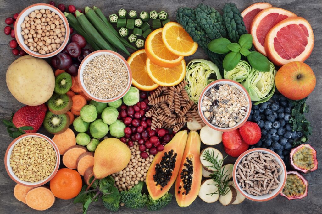 A spread of health foods for a high fiber diet with fruit, vegetables, cereals, whole wheat pasta, grains, legumes and herbs.